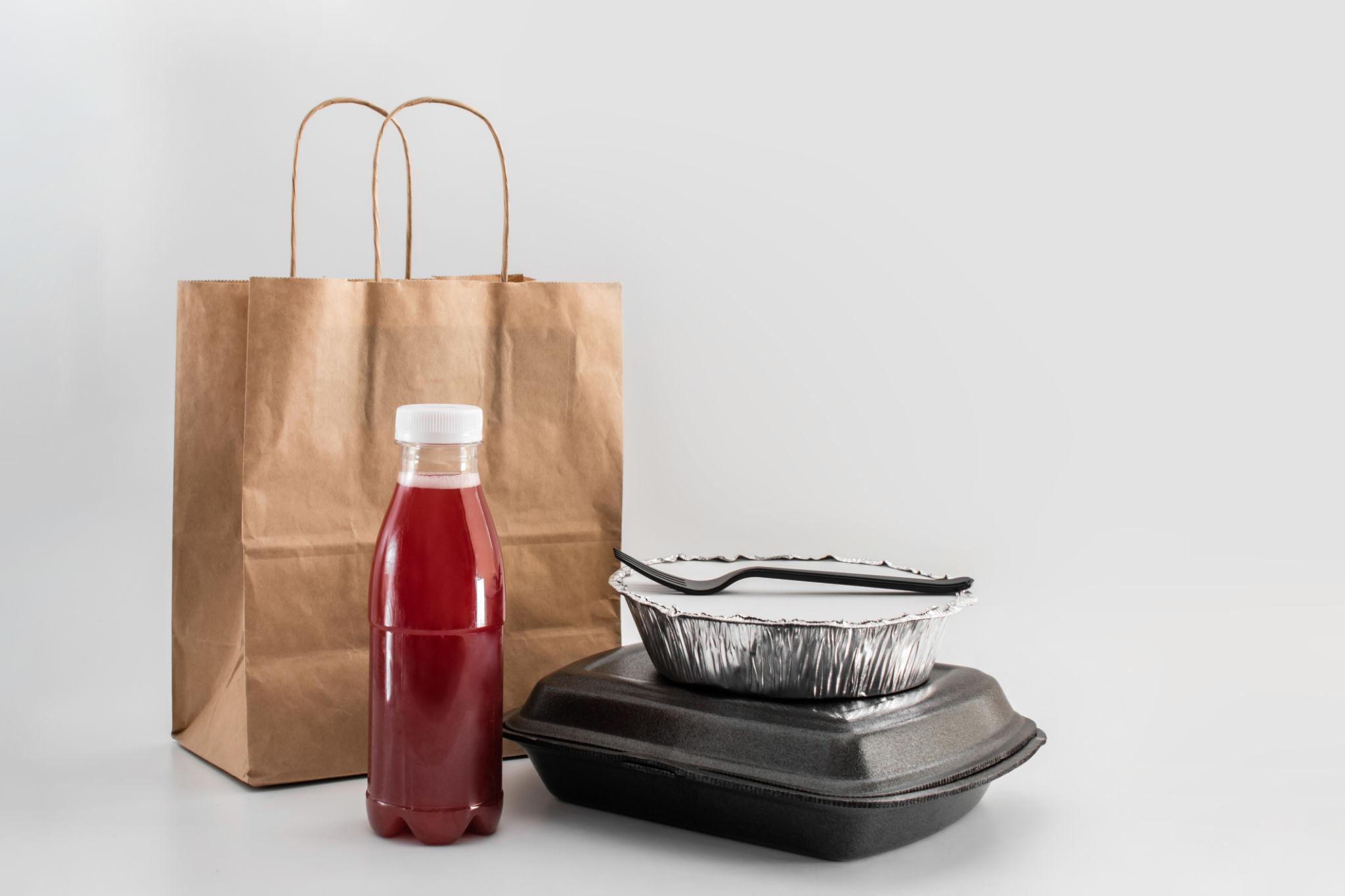 Restaurant takeaway packaging solutions with food containers, kraft boxes, and delivery bags in real use